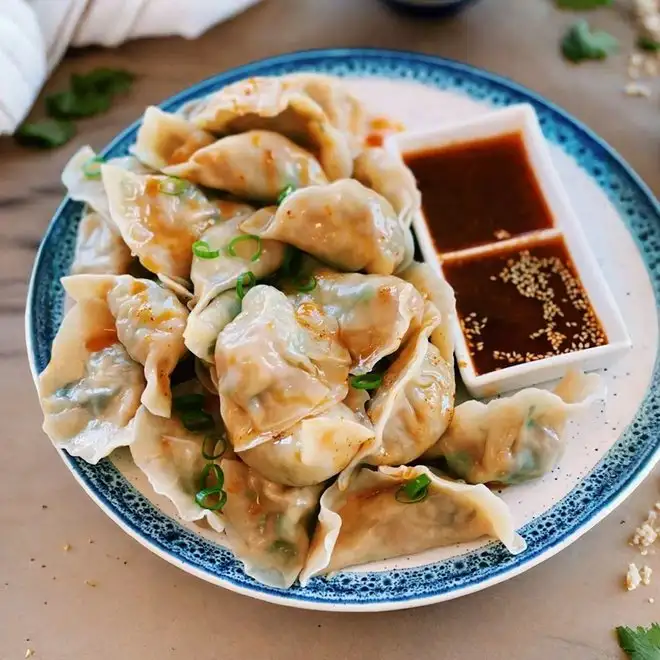 A plate of momos with dipping sauces